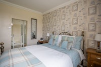 a bed in a bedroom with blue and white wallpaper