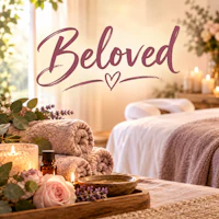 a spa room with candles and flowers and the word beloved