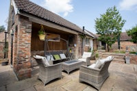 a brick patio with wicker furniture