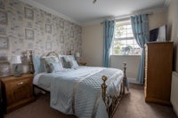 a bedroom with blue and white bedding and wallpaper