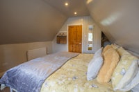 a bed in an attic room with a yellow comforter