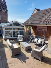 a patio with wicker furniture and a glass roof