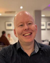 a bald man smiling in a restaurant