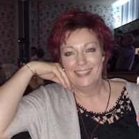 a woman with red hair posing for a photo in a restaurant