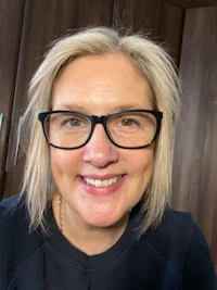 a woman in glasses smiling for the camera