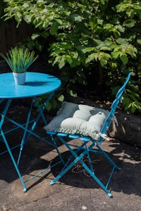 a blue folding table and chairs on a patio