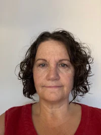 a woman in a red shirt with curly hair