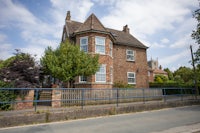 a brick house with a blue fence