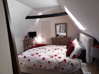 an attic bedroom with a bed and a dresser