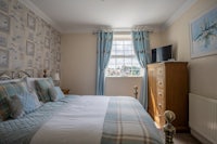 a bed in a bedroom with blue and white bedding